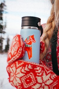 a woman holding a mug with a horse on it