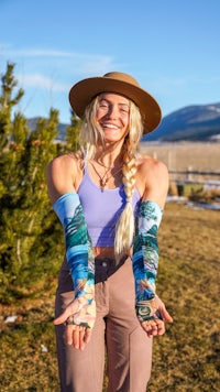 a woman wearing a hat and a pair of arm sleeves